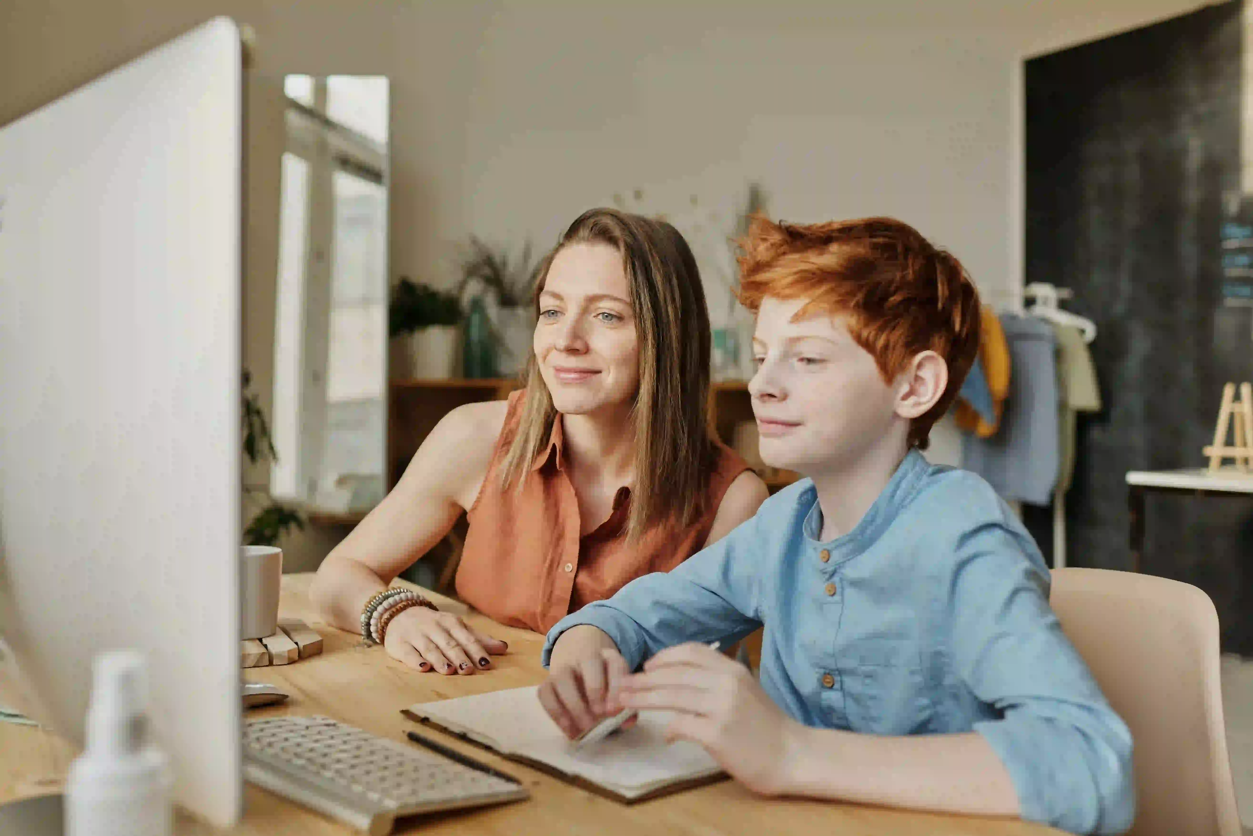 Boy studying with mum on computer